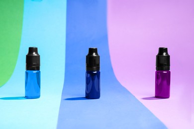 Photo of Bottles with different food coloring on bright background