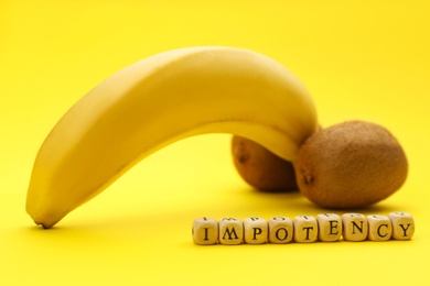 Photo of Fruits symbolizing male sexual organ and word IMPOTENCY on yellow background