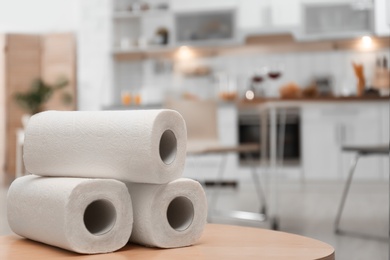 Rolls of paper towels on table in kitchen, space for text