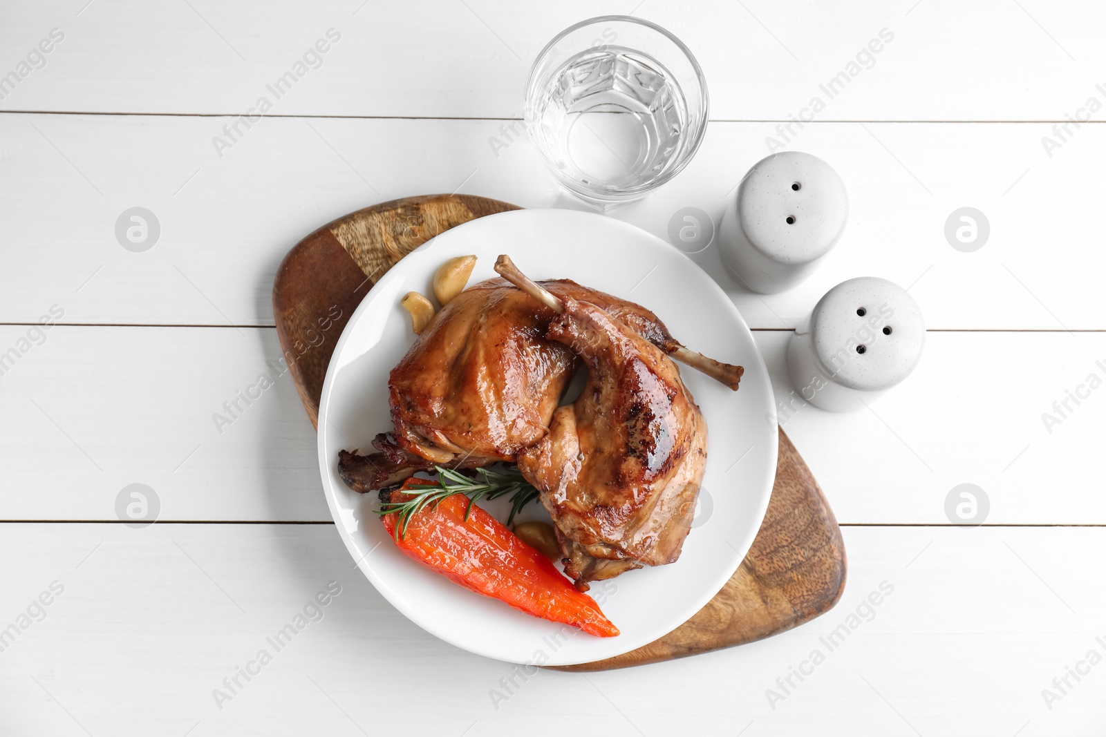 Photo of Tasty cooked rabbit meat served on white wooden table, flat lay