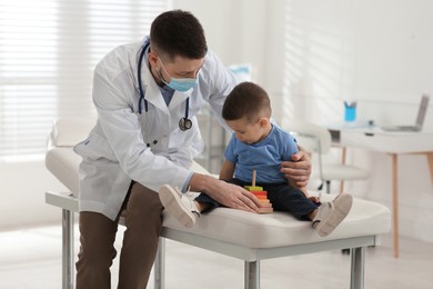 Photo of Pediatrician playing with little boy at hospital