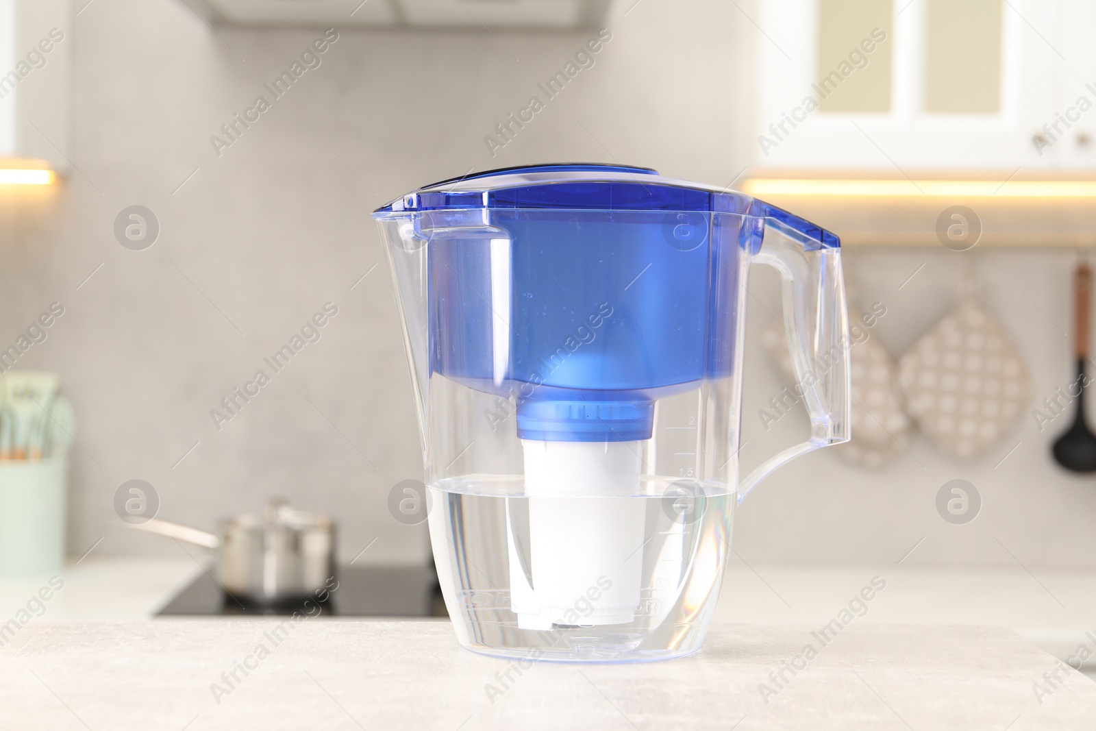 Photo of Water filter jug on light grey table in kitchen