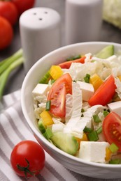 Photo of Tasty salad with Chinese cabbage, cheese, pepper, tomato and green onion on table, closeup