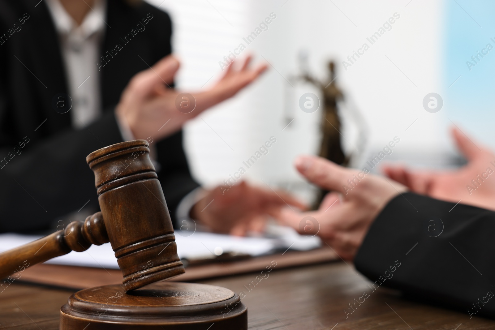 Photo of Woman having meeting with lawyer in office, focus on gavel