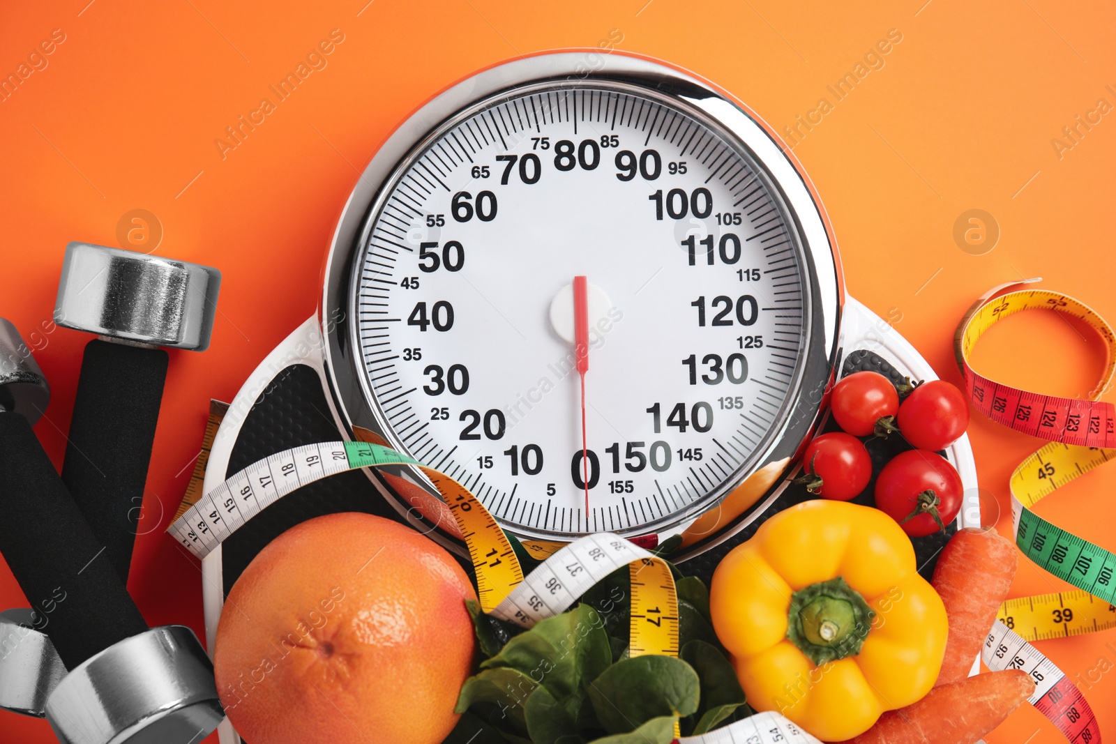 Flat lay composition with scales and healthy food on orange background Photo of Flat lay composition with scales and healthy food on orange background