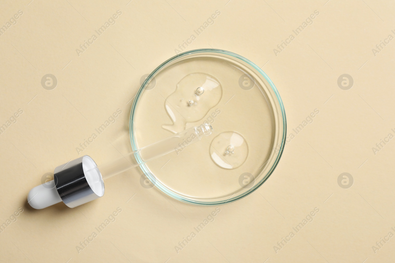 Photo of Petri dish with sample of cosmetic oil and pipette on beige background, top view