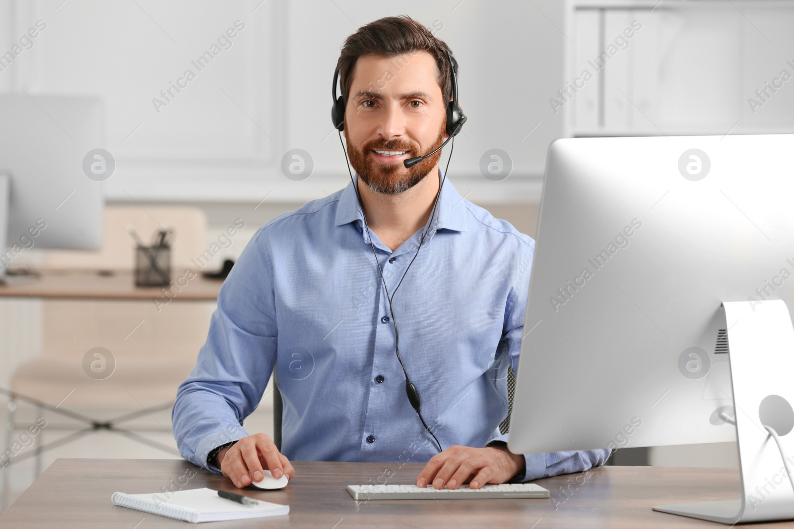 Photo of Hotline operator with headset working in office