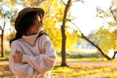 Photo of Beautiful young woman wearing stylish sweater in autumn park