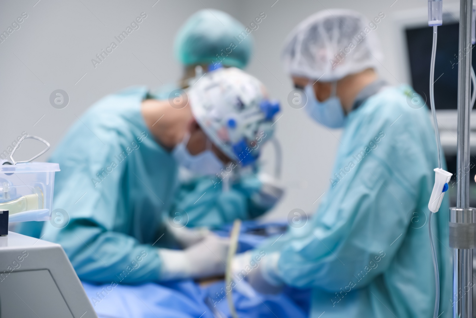 Photo of Blurred view of doctors operating patient in surgery room