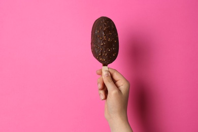 Photo of Woman holding delicious ice cream with chocolate against color background