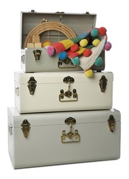 Photo of Stylish storage trunks with child's accessories on white background. Interior elements