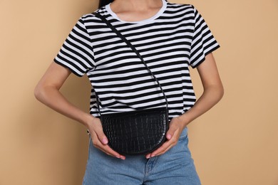 Photo of Woman with stylish bag on beige background, closeup