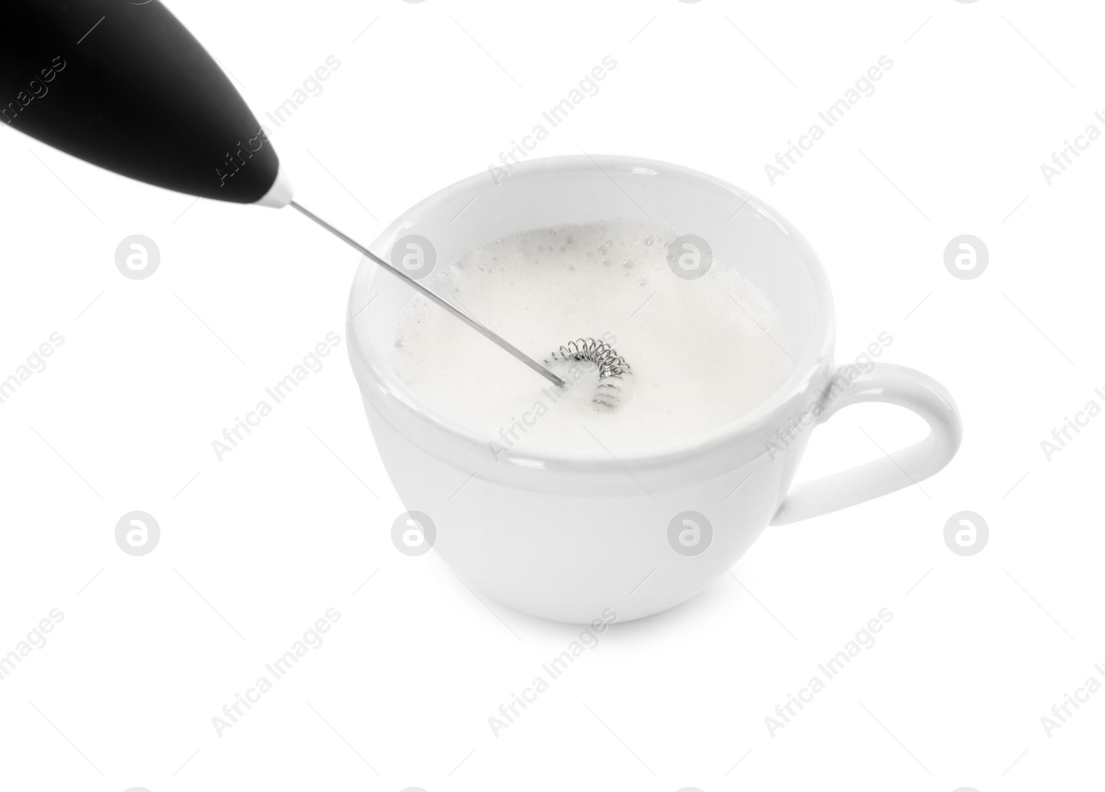 Photo of Whisking milk in cup with mini mixer (frother wand) isolated on white