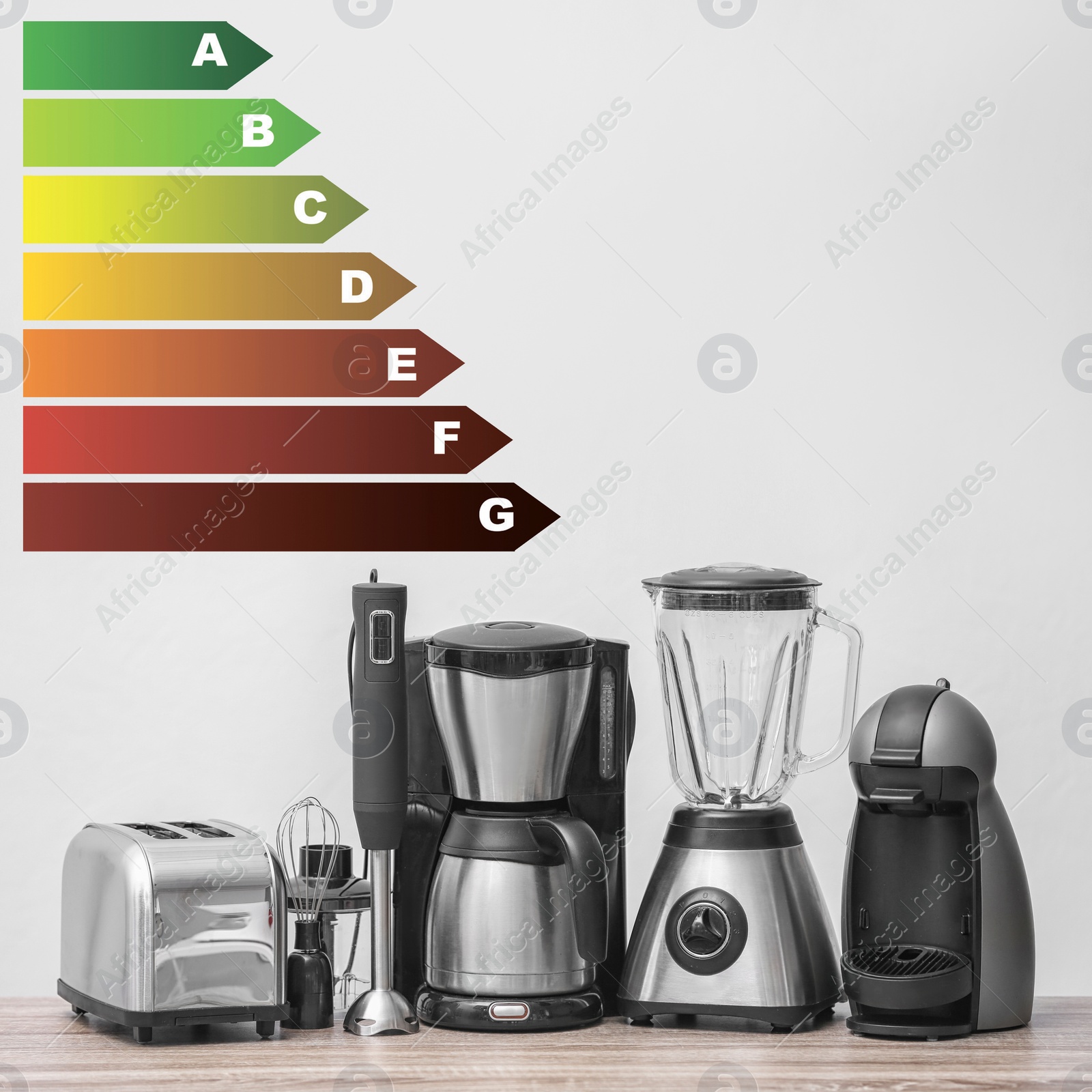 Image of Energy efficiency rating label and kitchen appliances on wooden table