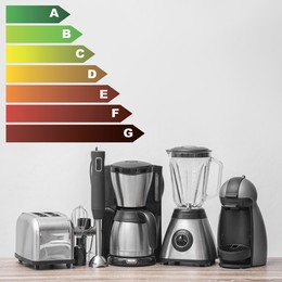 Energy efficiency rating label and kitchen appliances on wooden table