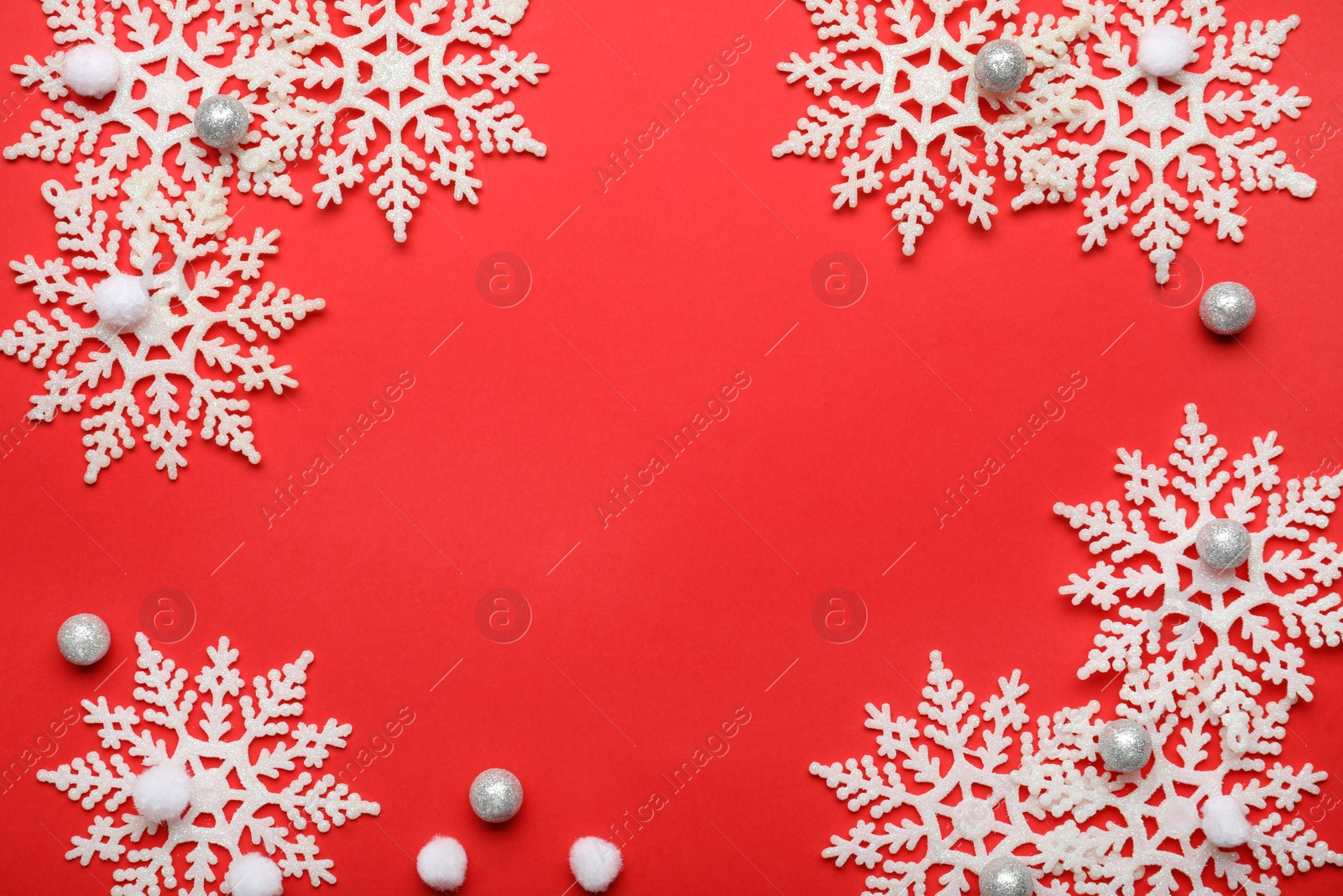 Photo of Beautiful decorative snowflakes on red background, flat lay. Space for text