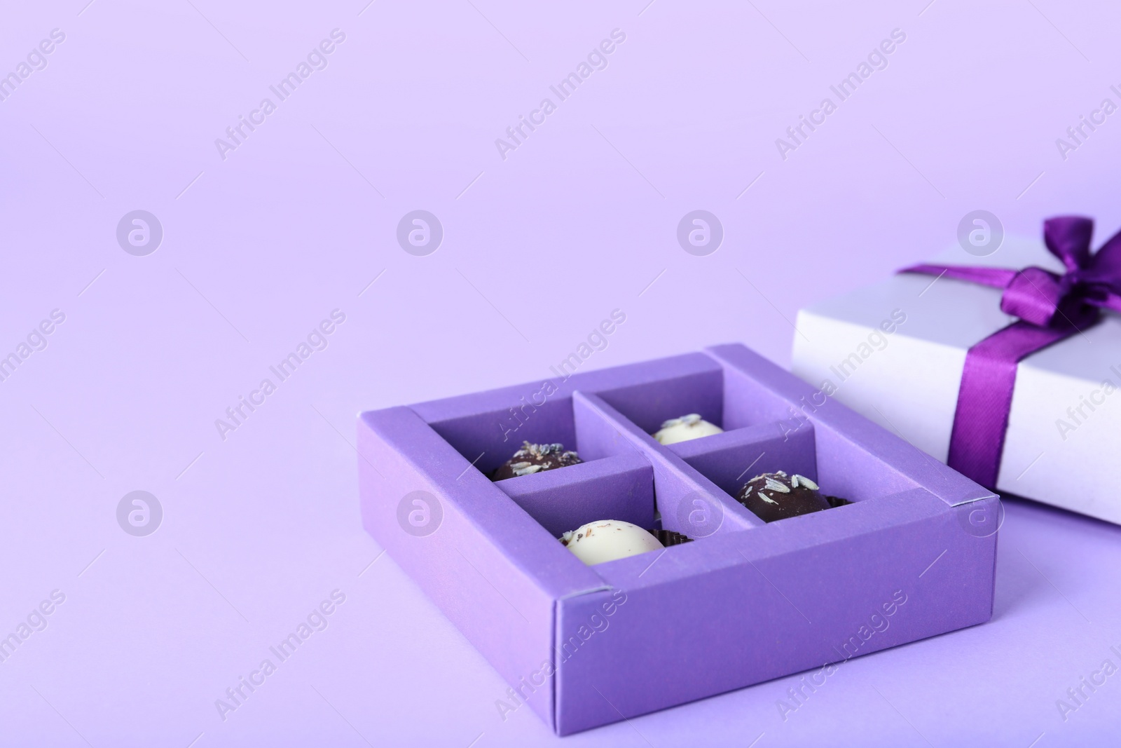 Photo of Box with delicious chocolate candies on white background