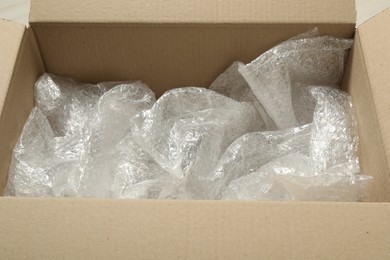 One open cardboard box with bubble wrap, closeup