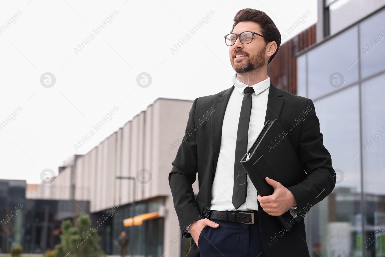 Photo of Real estate agent with leather portfolio outdoors. Space for text