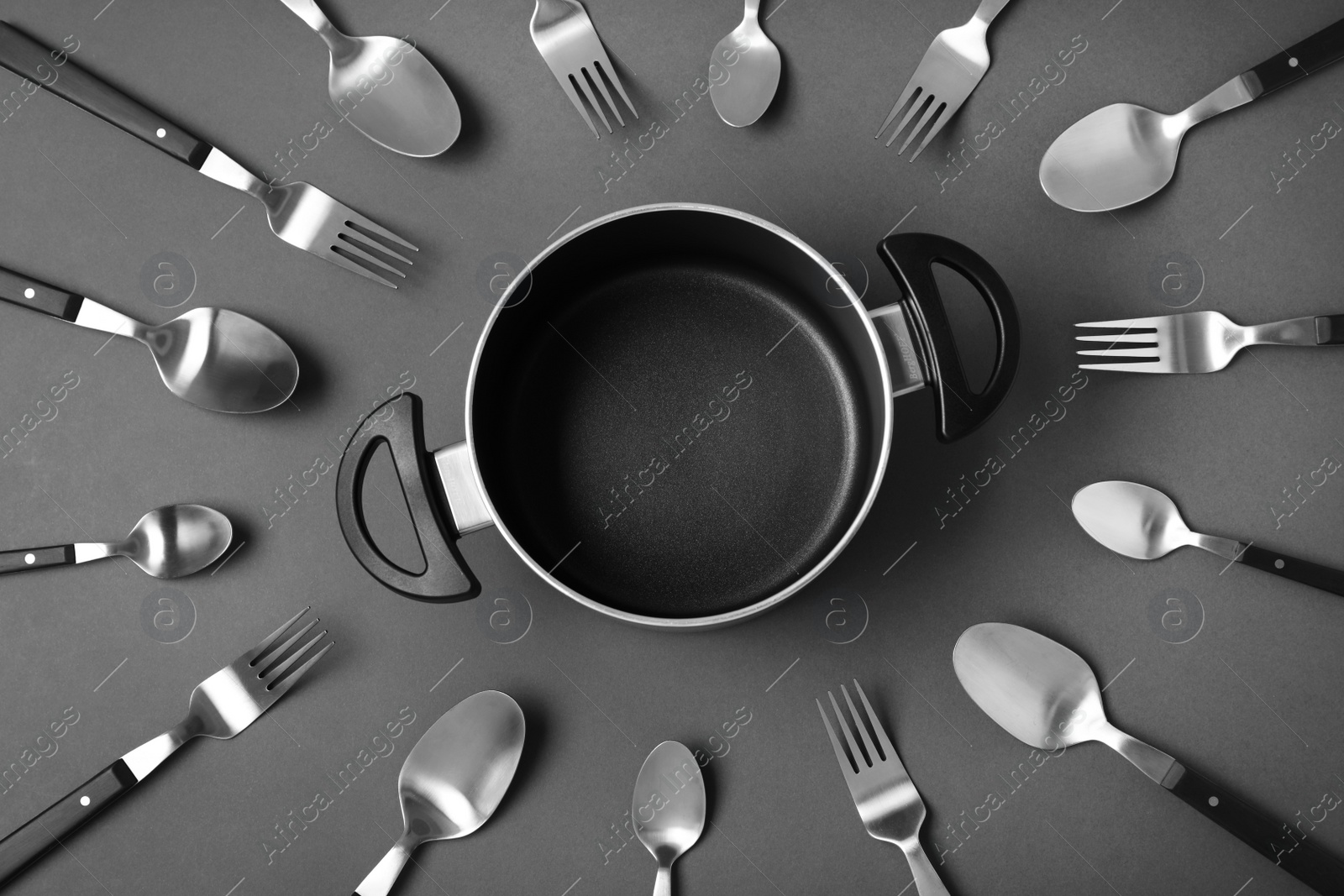 Photo of Flat lay composition with metal cutlery and empty pot on black background