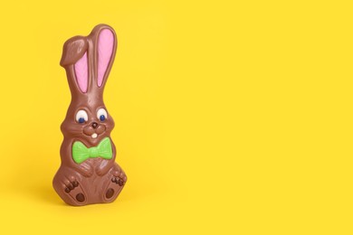Chocolate bunny on yellow background, space for text. Easter celebration