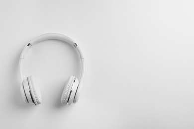 Photo of Stylish modern headphones with earmuffs on white background, top view. Space for text