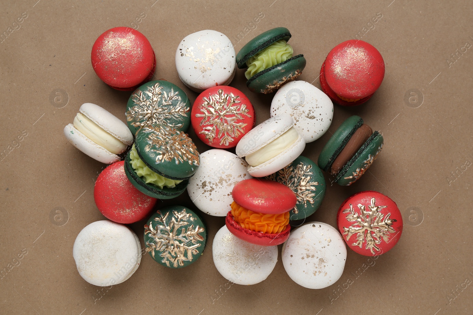 Photo of Beautifully decorated Christmas macarons on brown background, top view