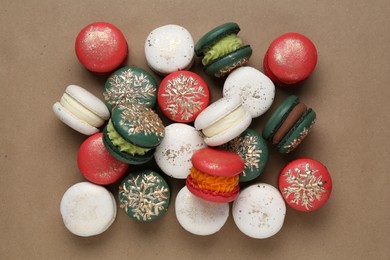 Photo of Beautifully decorated Christmas macarons on brown background, top view