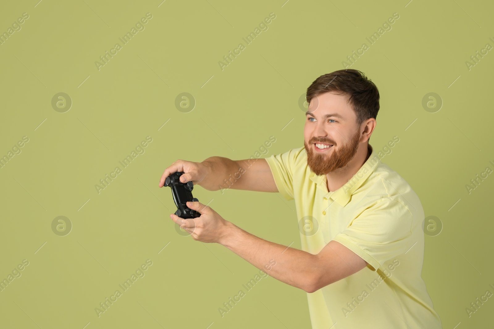 Photo of Happy man playing video game with controller on pale green background. Space for text