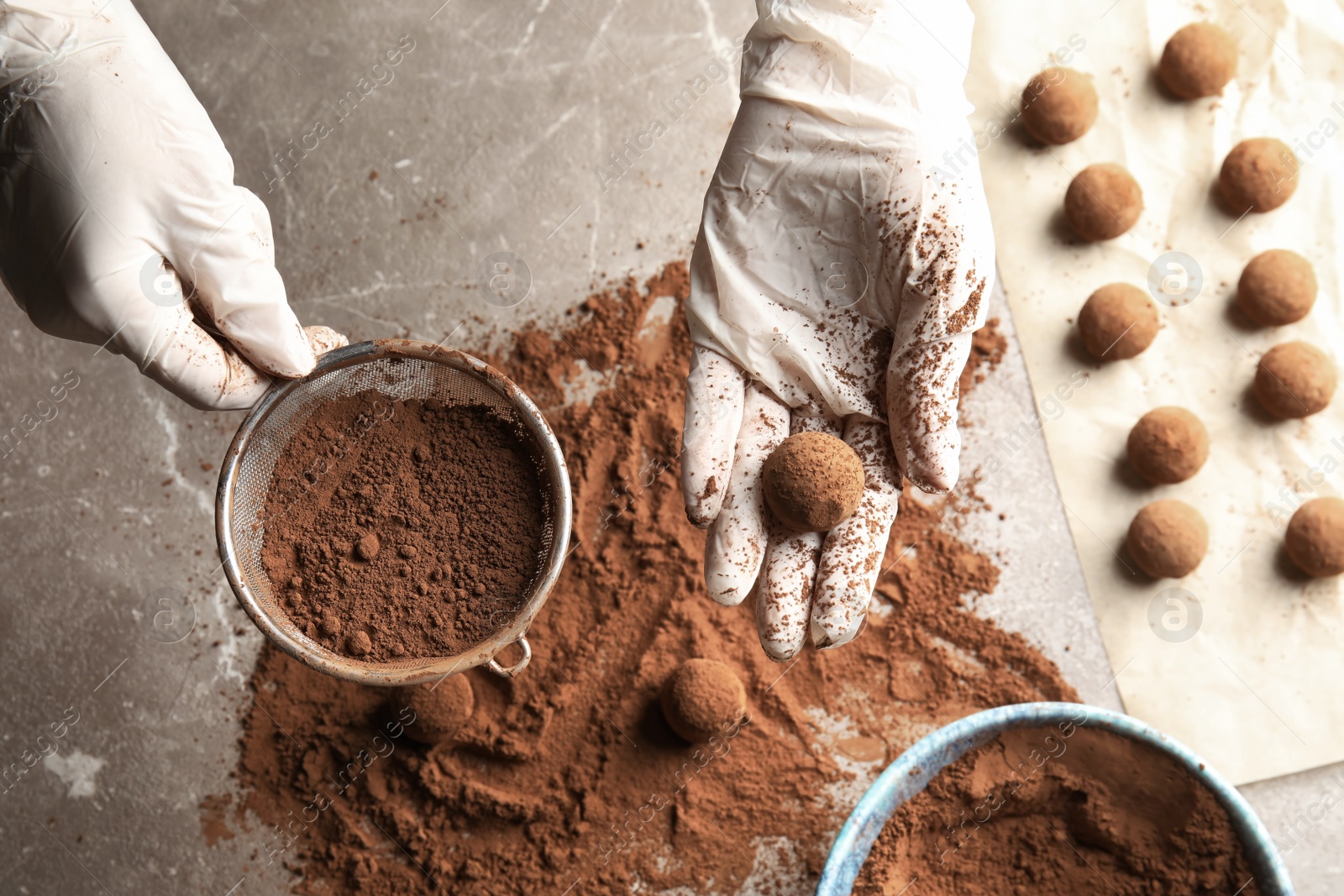 Photo of Woman preparing tasty chocolate truffles at table, top view