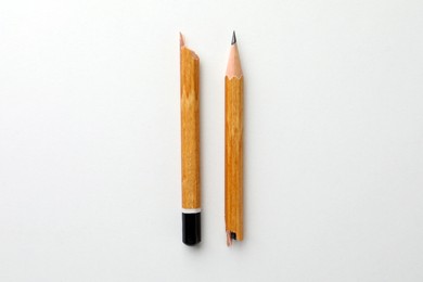 Photo of Broken pencil on white background, flat lay. Pause concept
