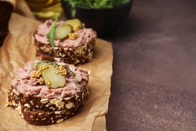 Delicious liverwurst sandwiches with pickled cucumber and mustard on grey table, closeup. Space for text