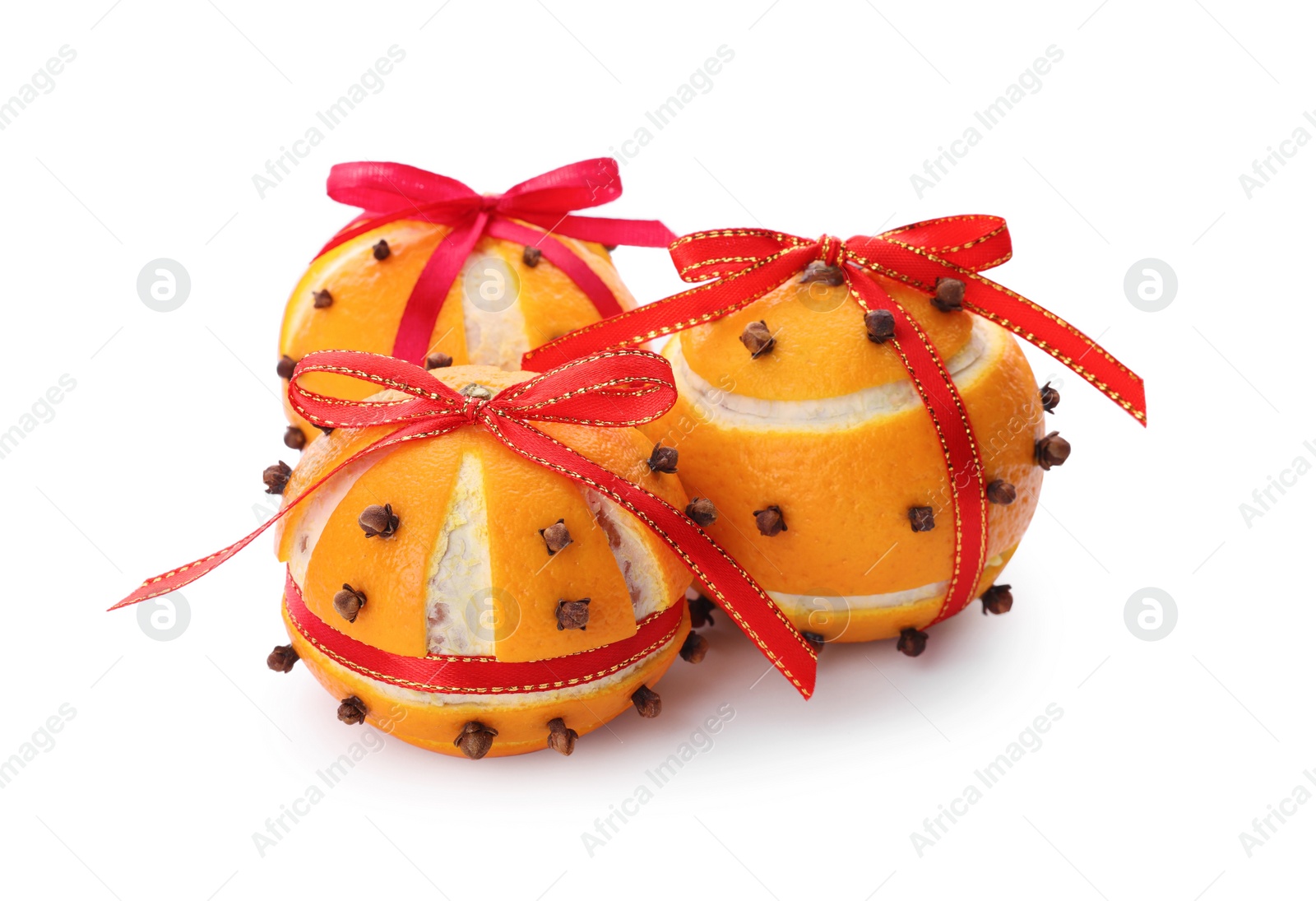 Photo of Pomander balls with red ribbons made of fresh tangerines and cloves on white background