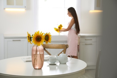 Bouquet of beautiful sunflowers on table in kitchen