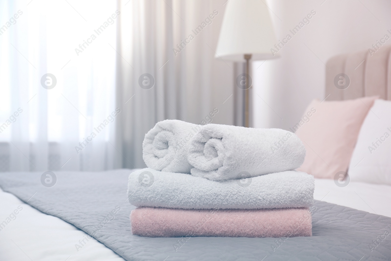 Photo of Soft clean towels on bed in room