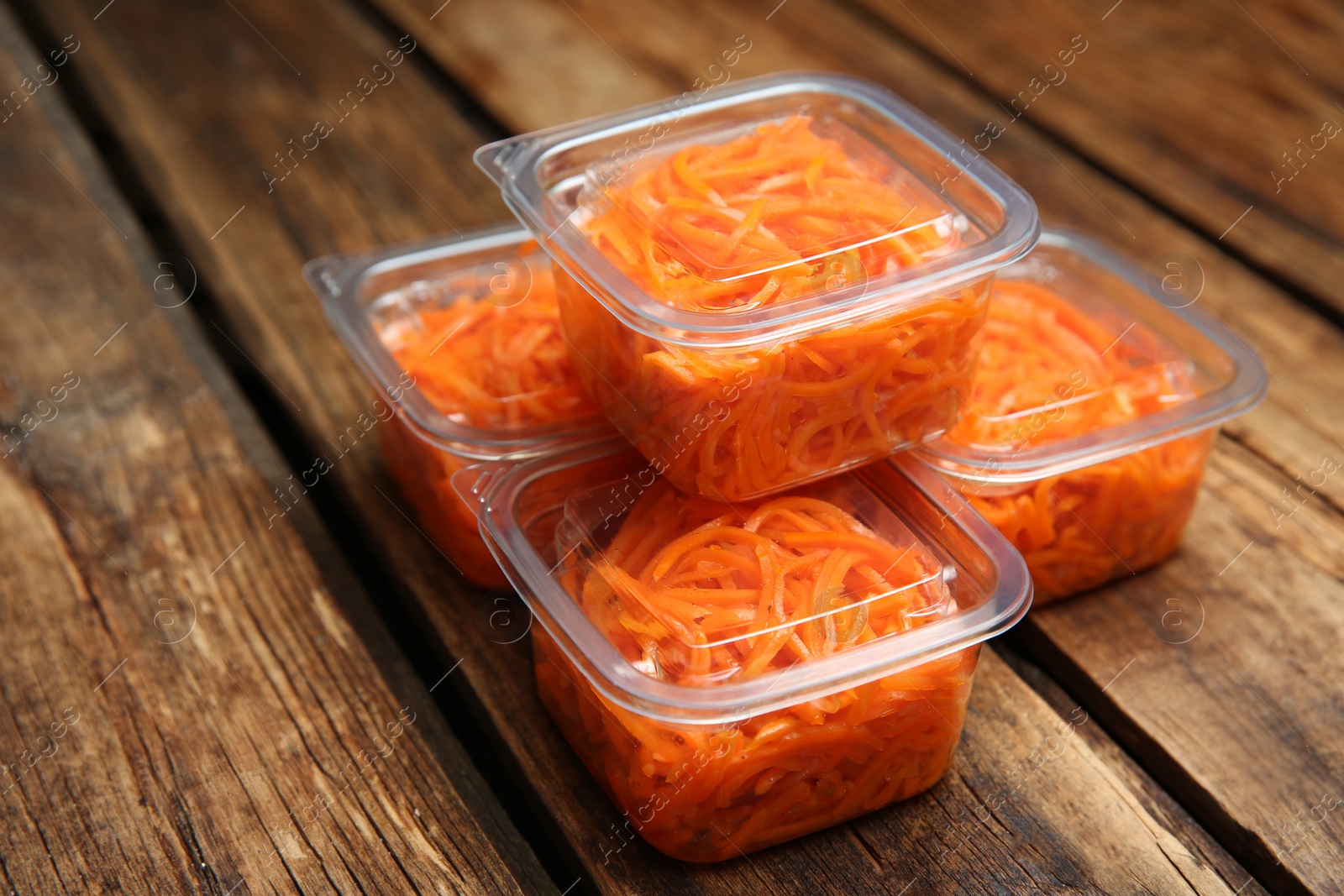 Photo of Plastic containers with tasty vegetable salad on wooden table, closeup. Food delivery service