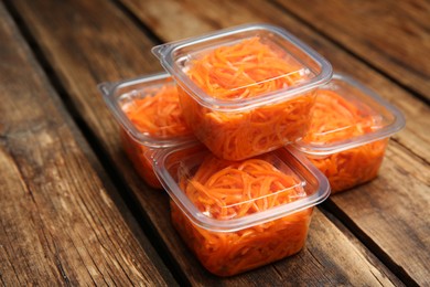 Photo of Plastic containers with tasty vegetable salad on wooden table, closeup. Food delivery service