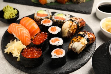 Photo of Set of delicious sushi rolls on light grey table