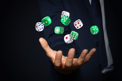 Image of Businessman throwing dice on black background, closeup