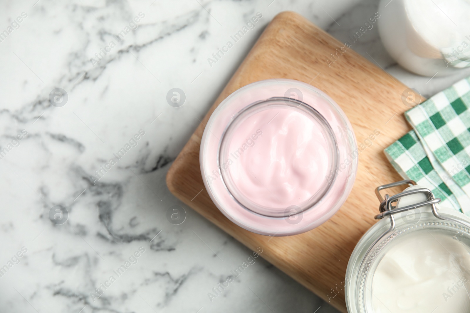 Photo of Flat lay composition with yogurts on marble background. Space for text