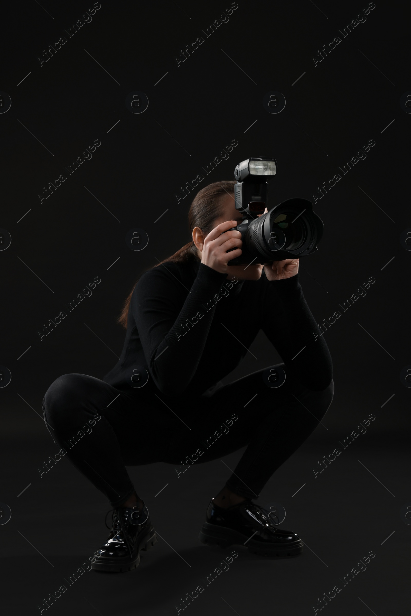 Photo of Professional photographer taking picture on black background