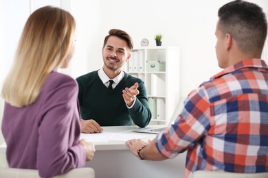 Real estate agent consulting young couple in office