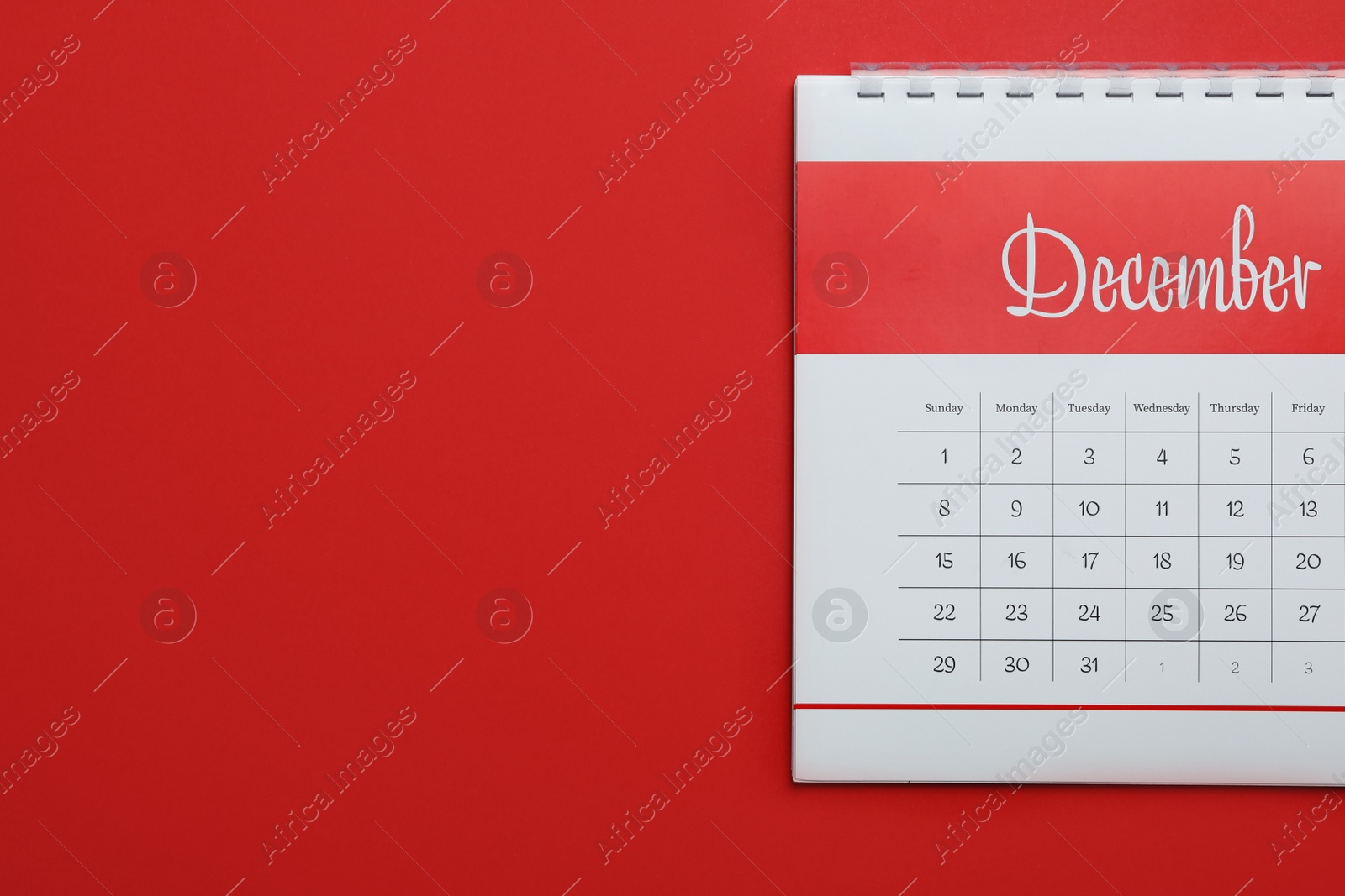 Photo of December calendar on red background, top view. Space for text