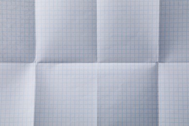Checkered sheet of paper with creases as background, closeup