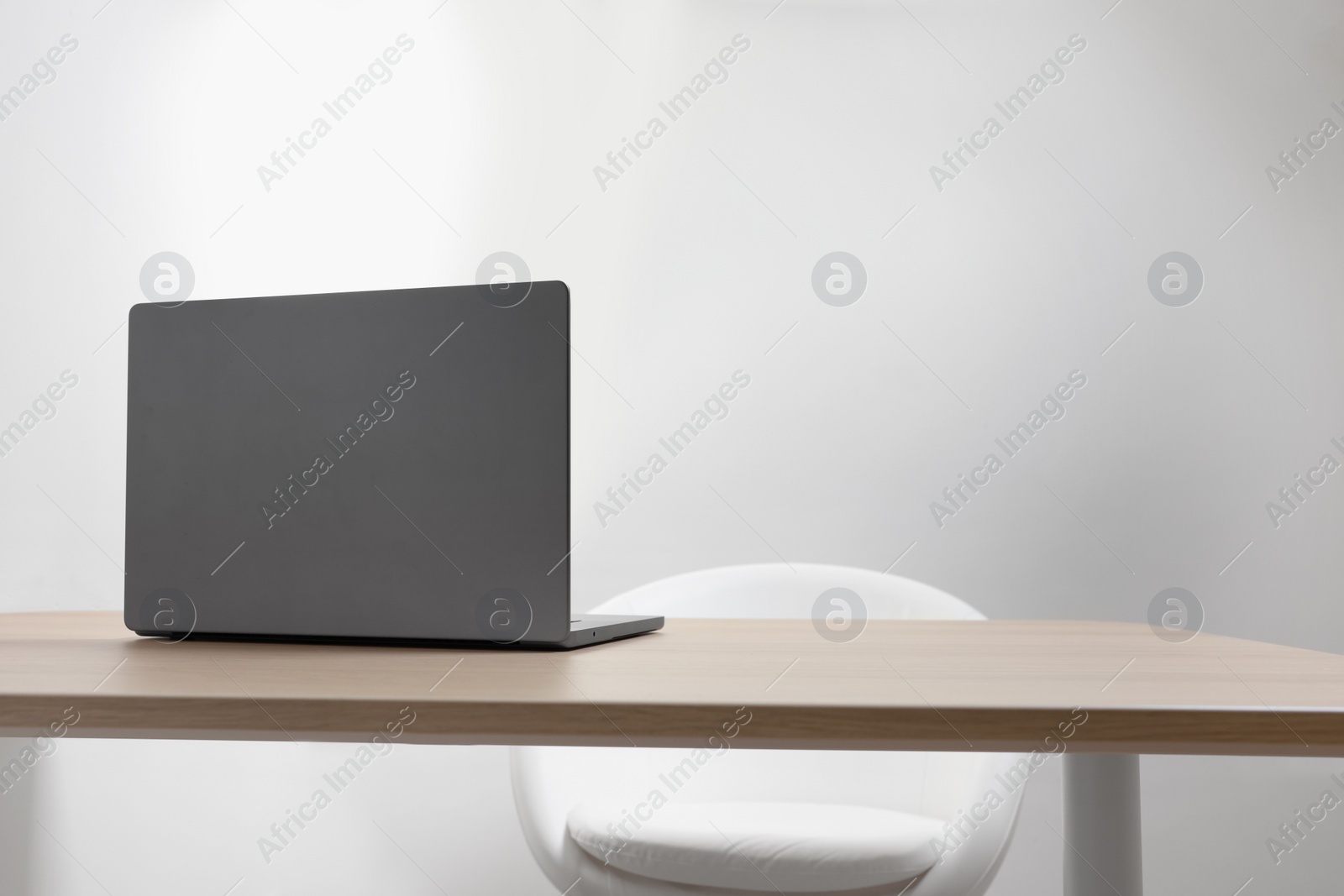 Photo of Stylish modern laptop on wooden table indoors. Space for text