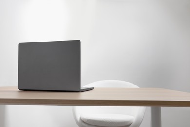 Photo of Stylish modern laptop on wooden table indoors. Space for text