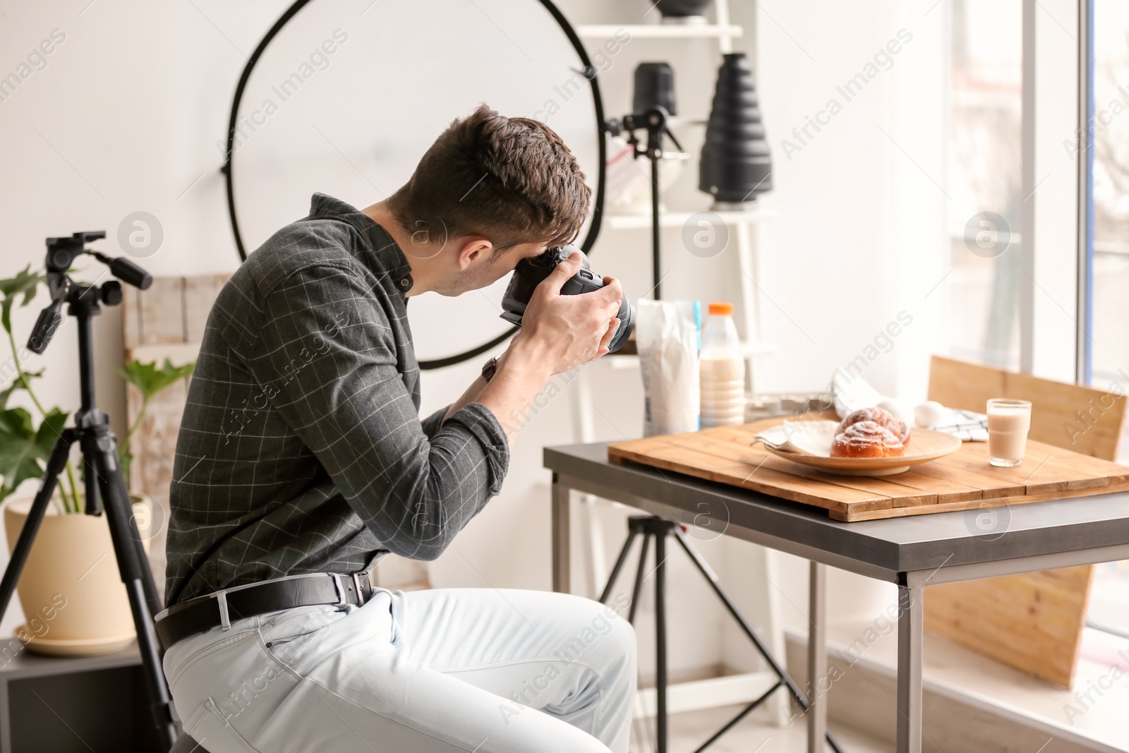 Photo of Young man taking picture of food in photo studio