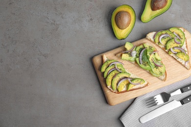 Photo of Flat lay composition with avocado toasts on grey table. Space for text