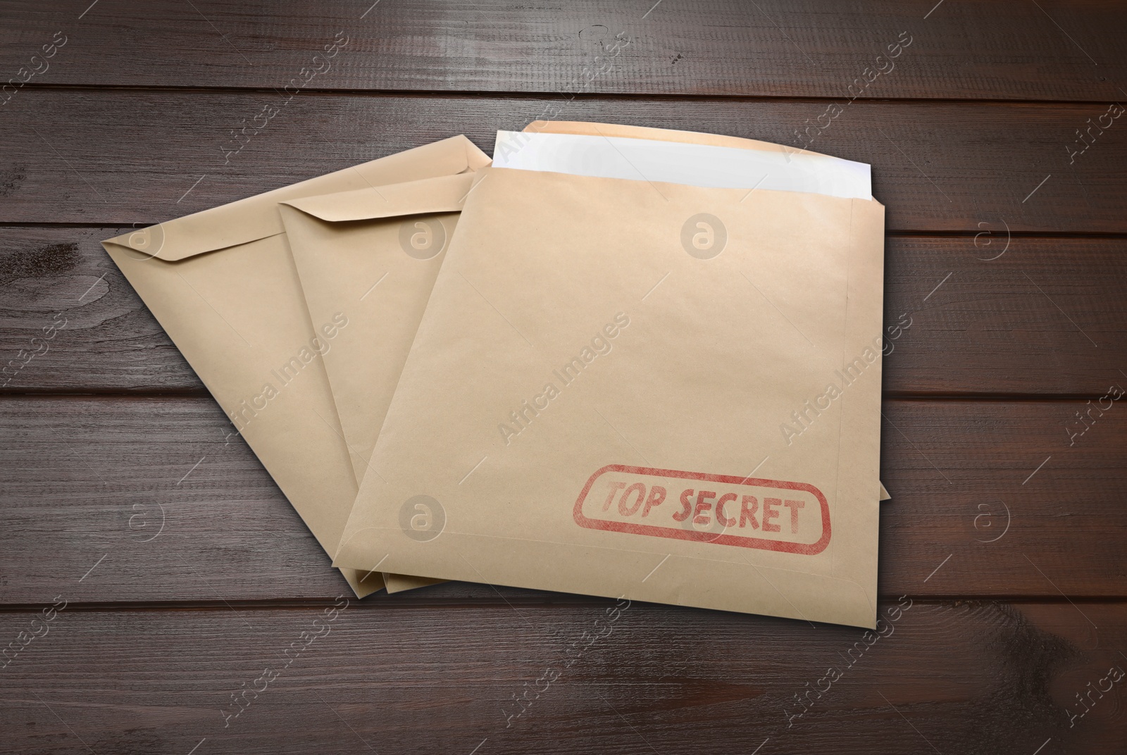 Image of Top Secret stamp. Paper envelopes on wooden table