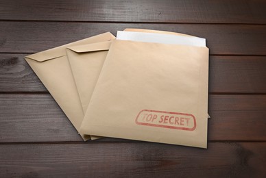 Image of Top Secret stamp. Paper envelopes on wooden table